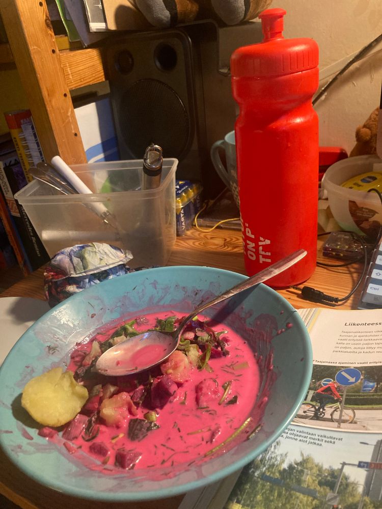 Pinkkiä kylmää punajuurikeittoa lautasella työpöydällä perunan kera 