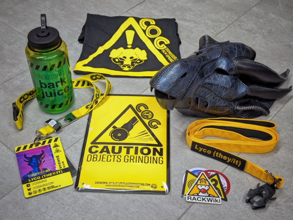 My swag from COG Weekend 2025 by Shiny Dog Productions: Soft ringspun screenprinted T-shirt, Nalgene® water bottle, embossed metal sign, vinyl stickers, lanyard with release buckle & bottle opener, plastic personalized photo ID event badge, & personalized embroidered name patch attached to a long/short combo leash featuring a quick connect latch & neoprene handles... talk about QUALITY