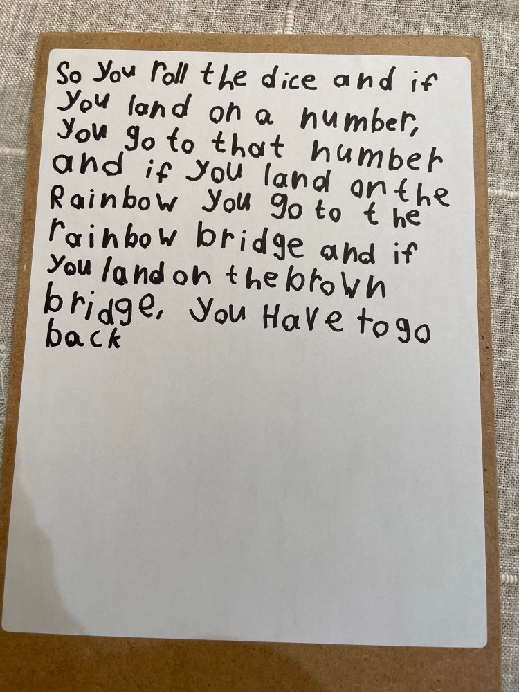 Game instructions printed by six year old on white board in black marker.