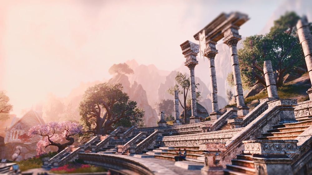 ESO screenshot. Ancient stone ruins and staircase with flowering trees in a serene, hazy landscape.