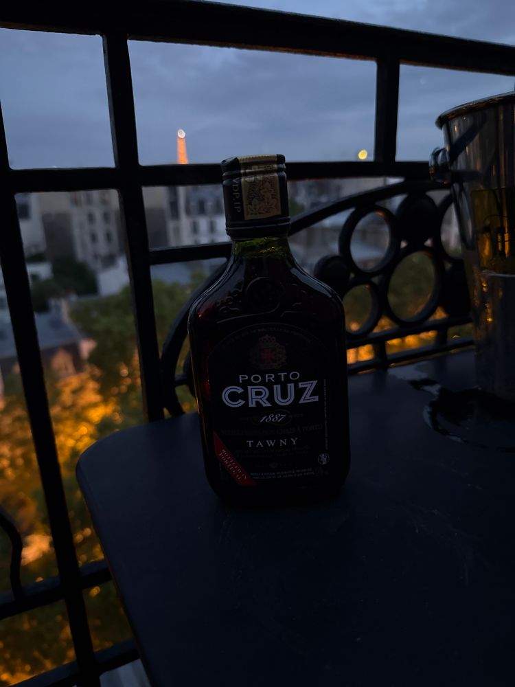 A small bottle of port wine with the Eiffel Tower in the background 