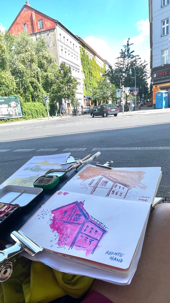 A sketchbook on my lap, sketching the House on location with watercolour and coloured pencils.
