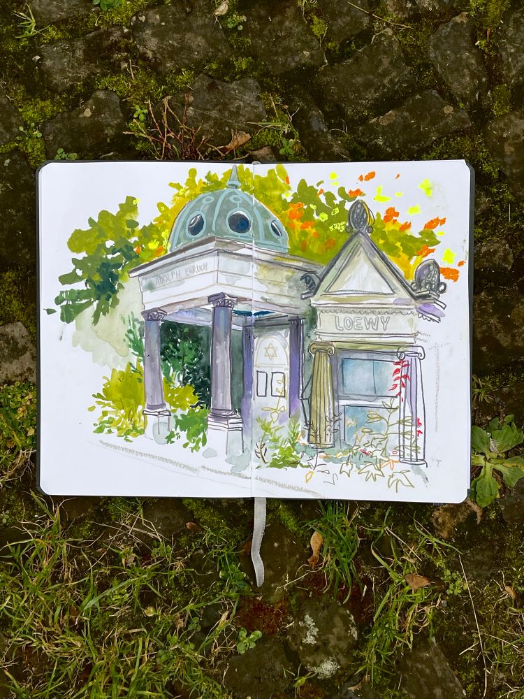 An open sketchbook with a sketch of a Jewish burial site. The’re leaves in orange and green.