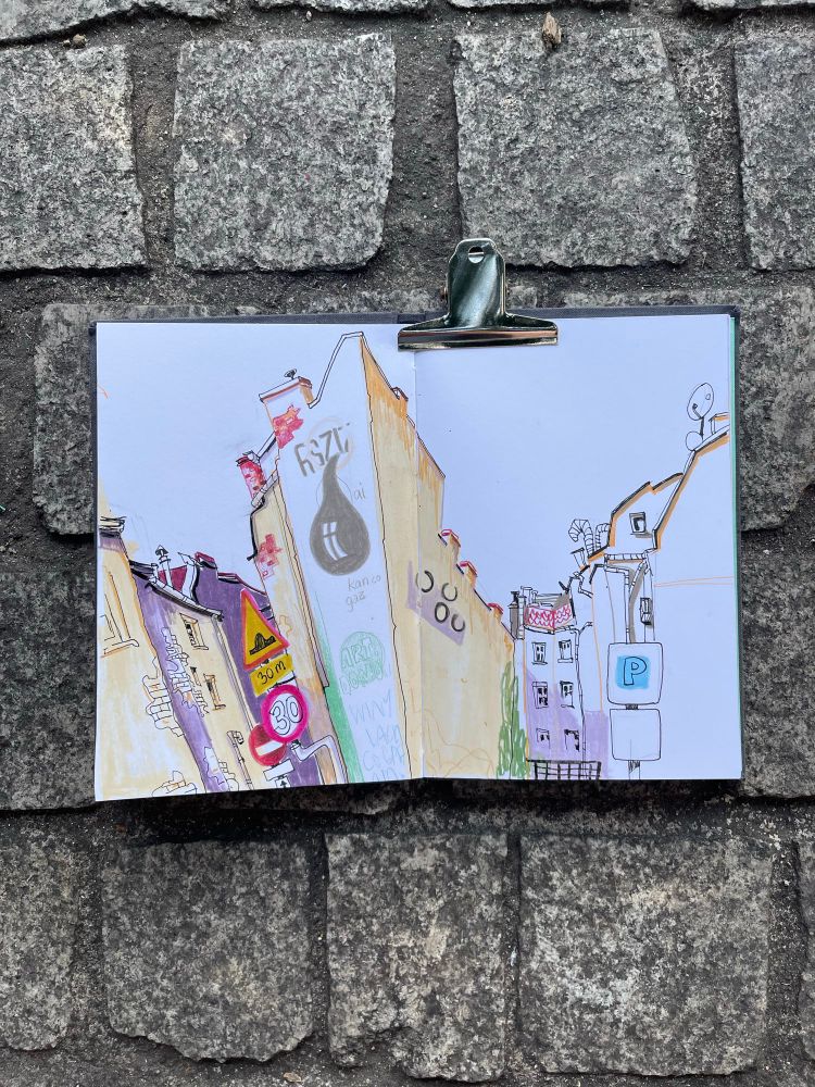 A sketchbook with a sketch of some houses.