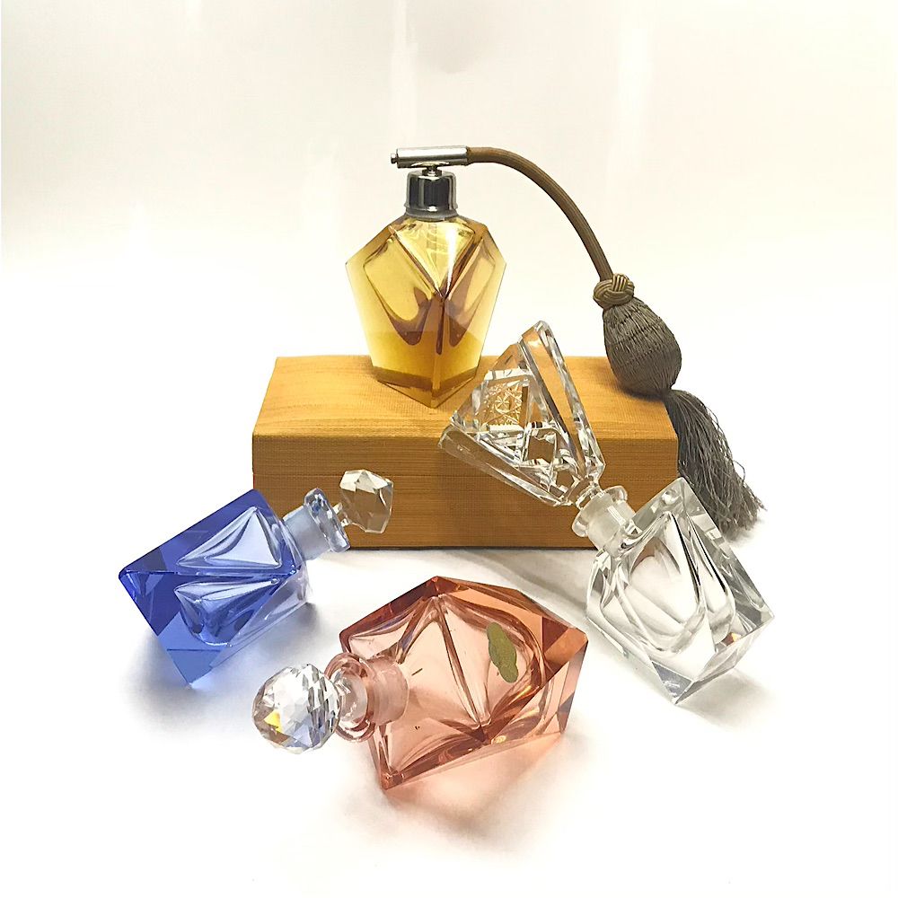 Display of 4 vintage cut crystal scent bottles in varying colours. 