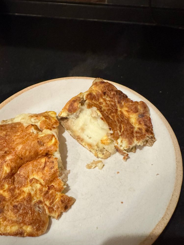 Omelet opened to reveal mashed potatoes, stuffing, turkey. 