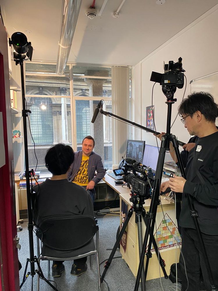 Two members of NHK crew are filming Dr Rafal Zaborowski in his office on King's Strand Campus.