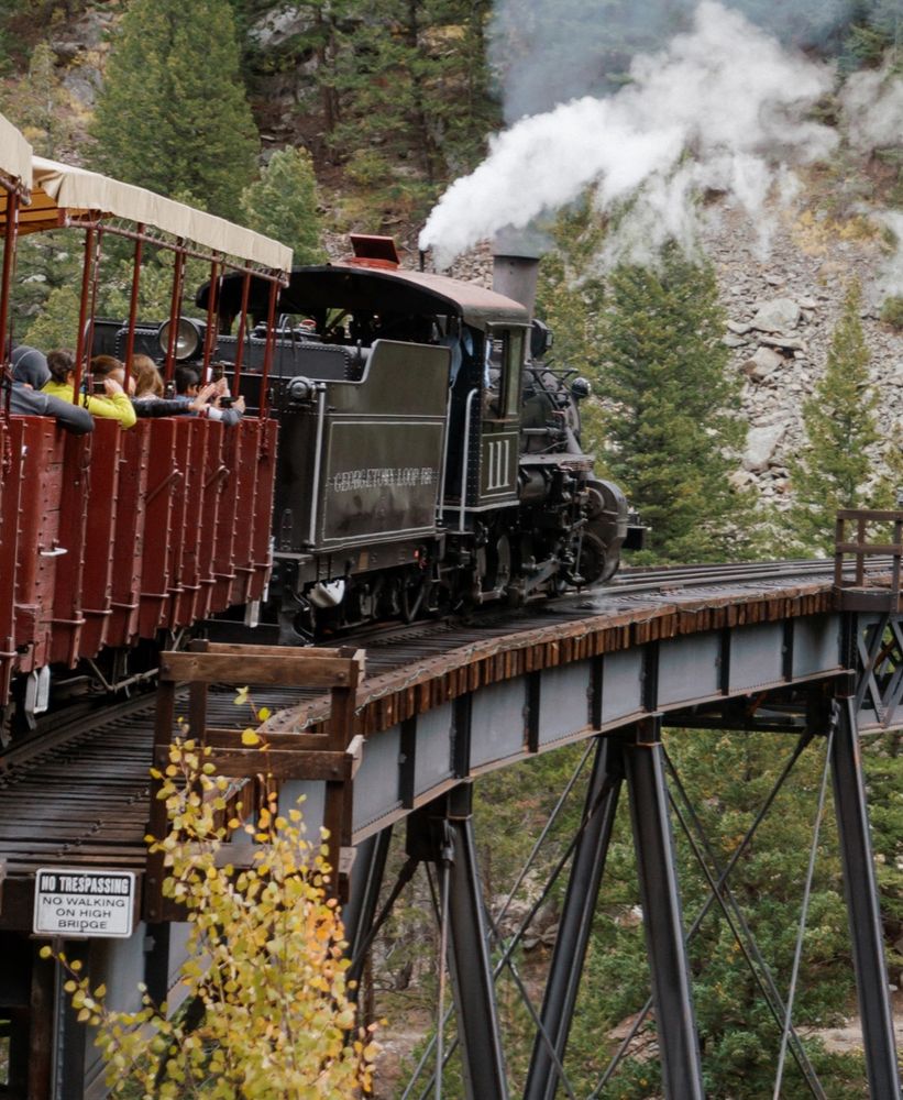 Steam train crossing a bridge in the Colorado mountains.