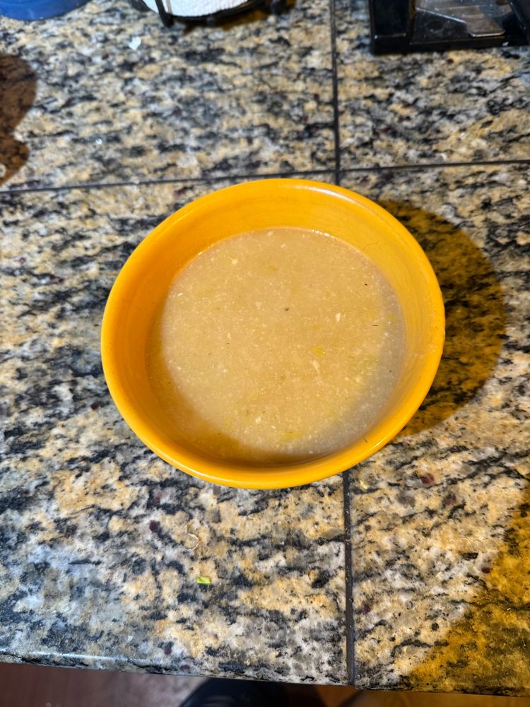 Yellow bowl filled with leek soup.