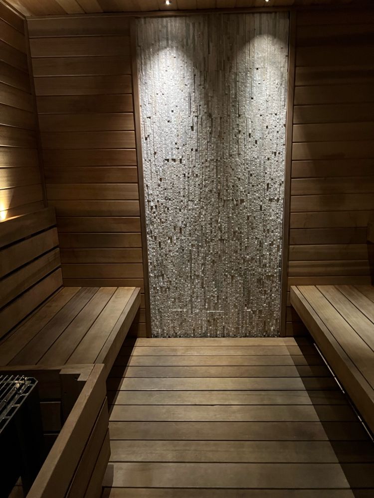 A peaceful, empty sauna with warm wooden benches and soft, glowing light, creating a serene and calming atmosphere.