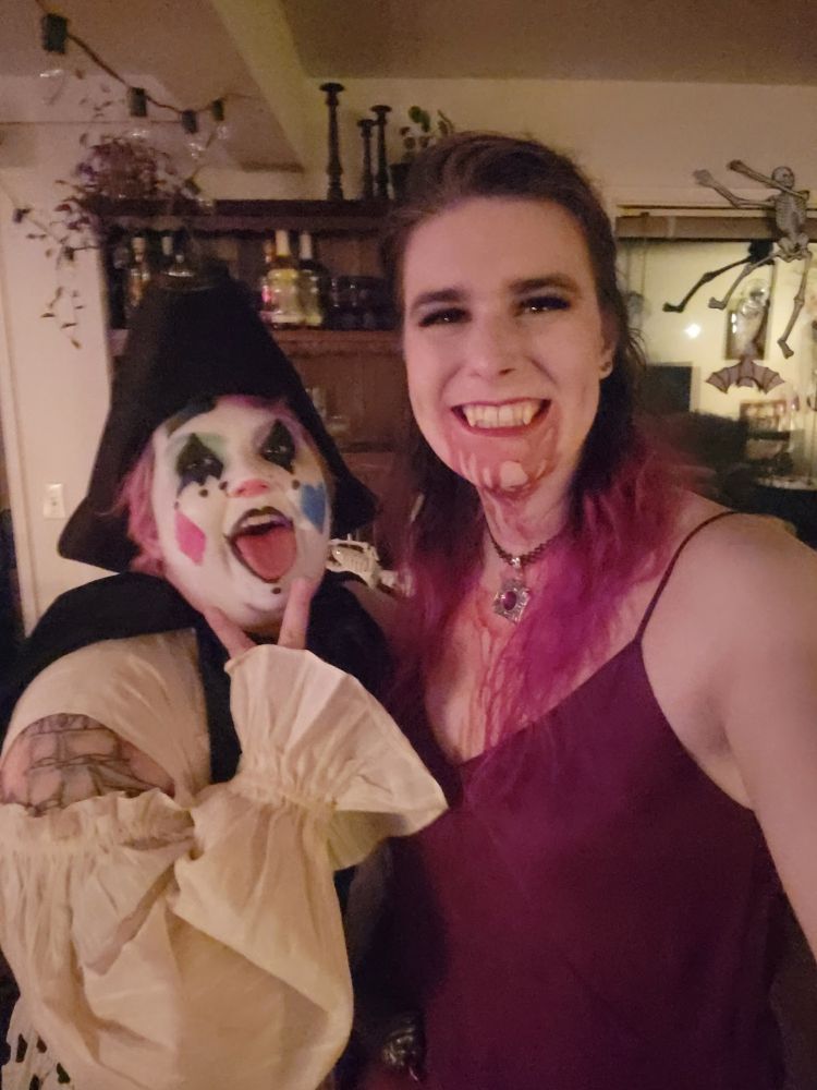 @maxiest.bsky.social dressed as a pirate clown and me dressed as a vampire covered in blood posing for a selfie