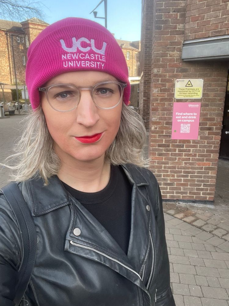 Selfie of me in a pink UCU NEWCASTLE UNIVERSITY hat, black jacket, black dress 
