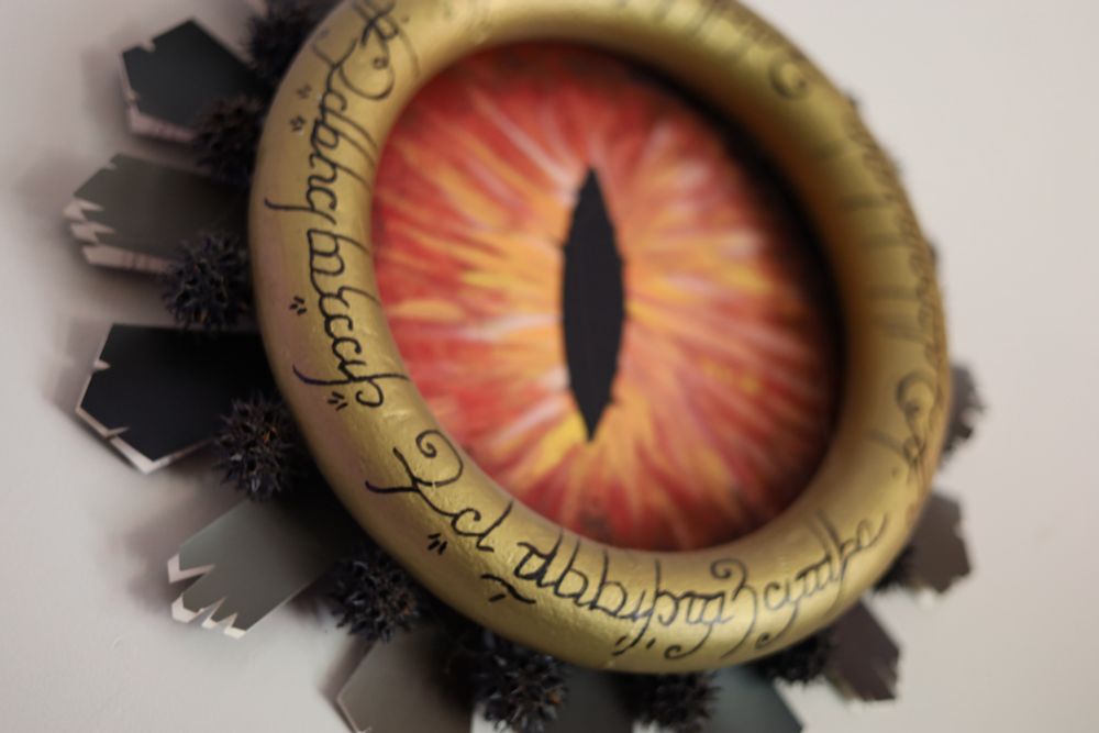 An eye of Sauron wreath with hand painted elvish marks around it and Sauron’s eye painted in the middle.