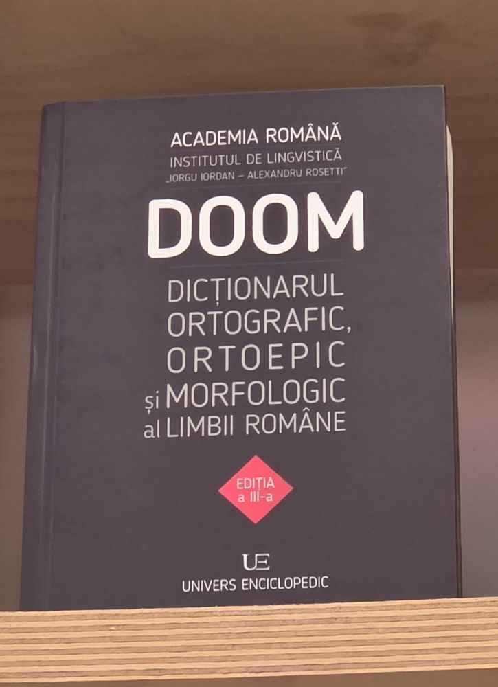 Bilete av ei bok med tittelen DOOM  (som står for Dictionariul ortografic, ortoepic și morfologic al limbii române- altså Den ortografiske, ortoepiske og morforlogiske ordboka for det rumenske språket)