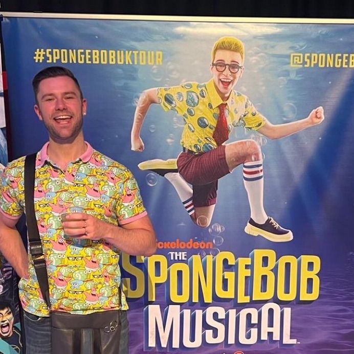 Paul in front of poster for SpongeBob the musical