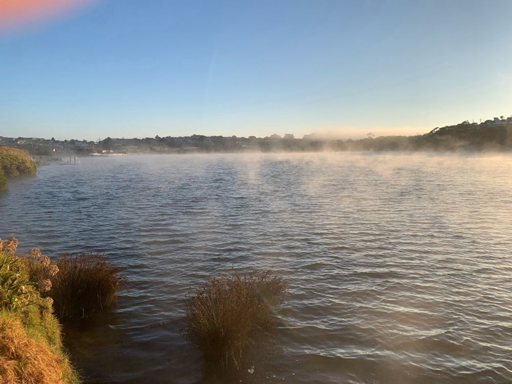 River shortly after sunrise with some thinning fog above it.