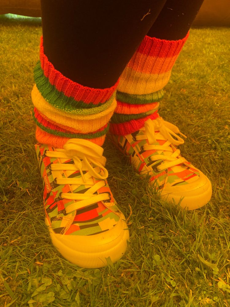 A pair of feet in colourful shoes and leg warmers