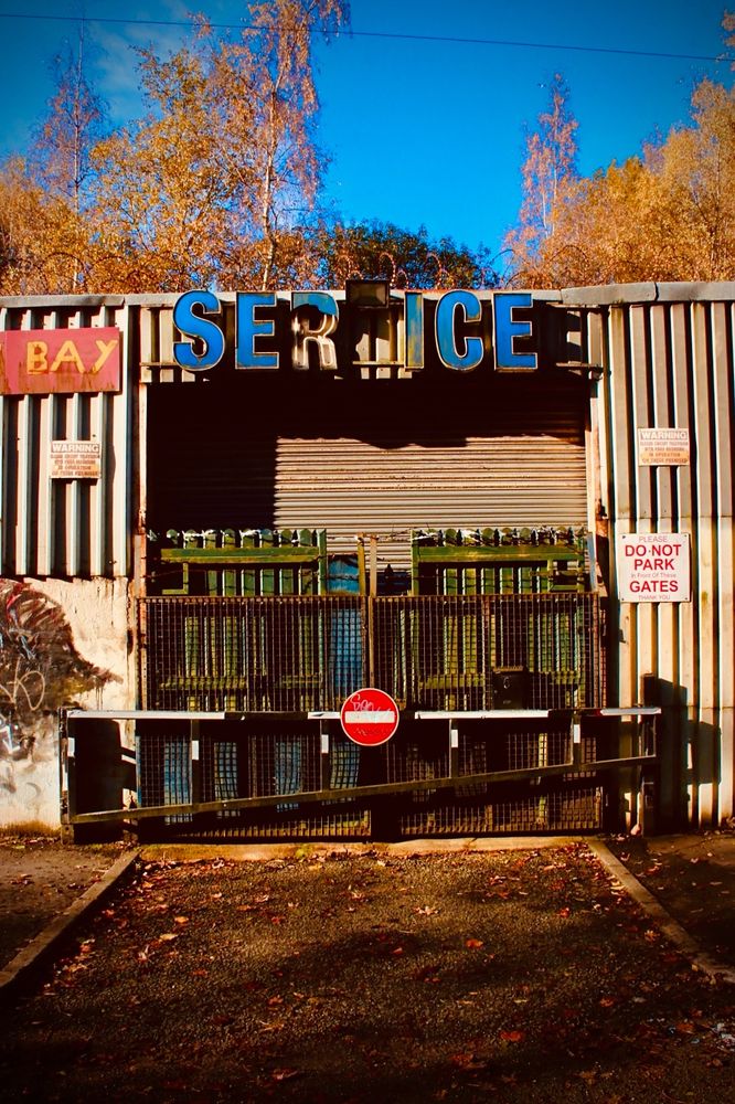 An old entrance to a garage no longer in use. The sign at the top says SER ICE presumably missing a V in the middle