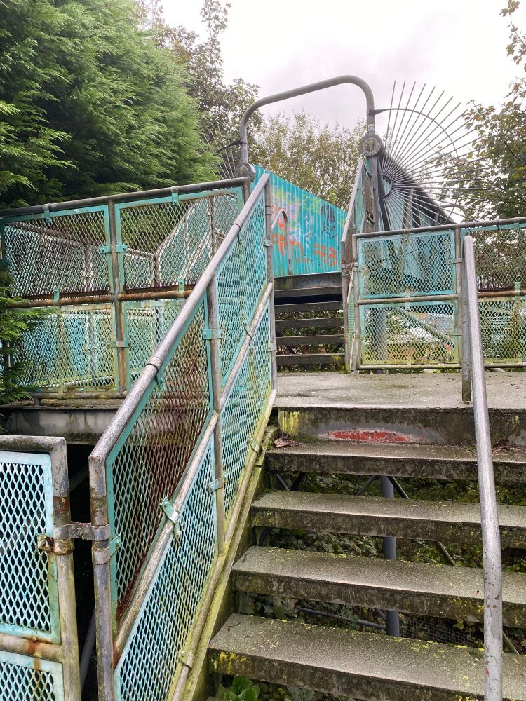 Steps leading up to a rusty iron bridge
