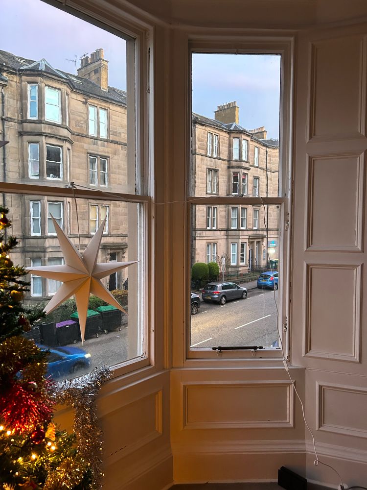 View out of a window onto a street lined with tenement buildings