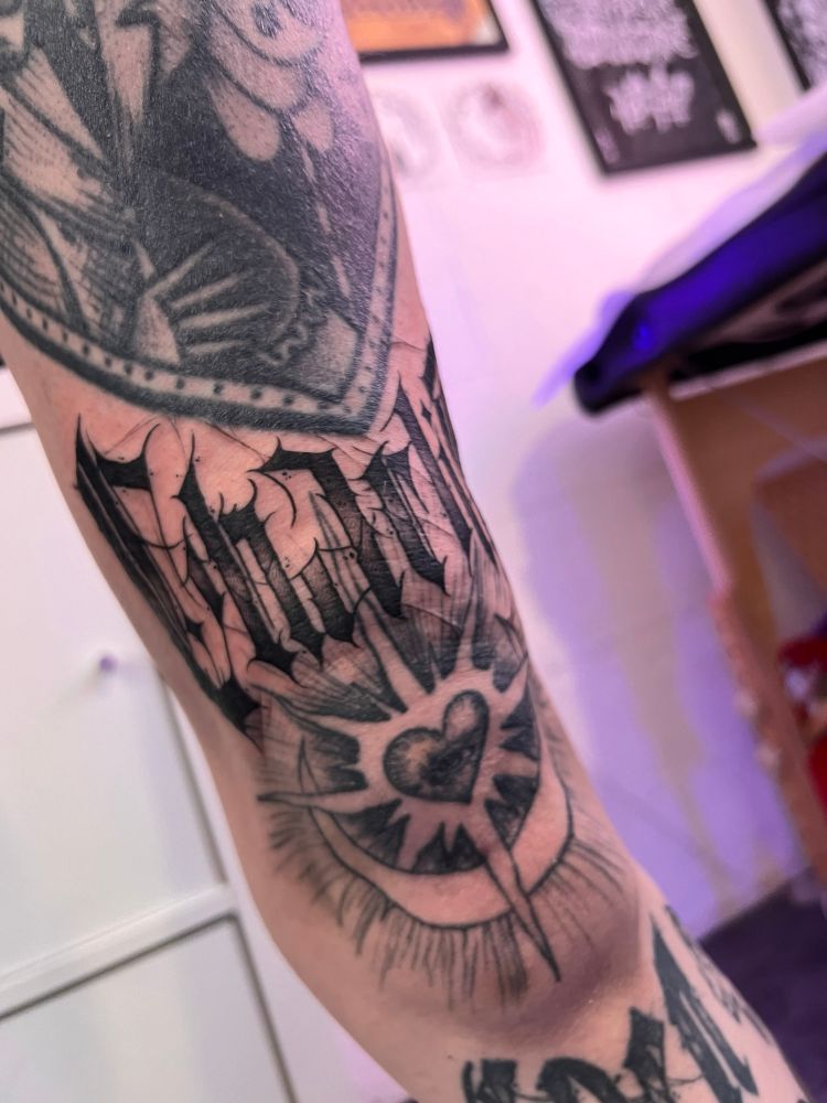 Un tatouage placer au dessus du genoux un peu en blast pout passer entre deux tattoo déjà existant. C’est une typo avec marqué : « CharliE » en lettrage dark.