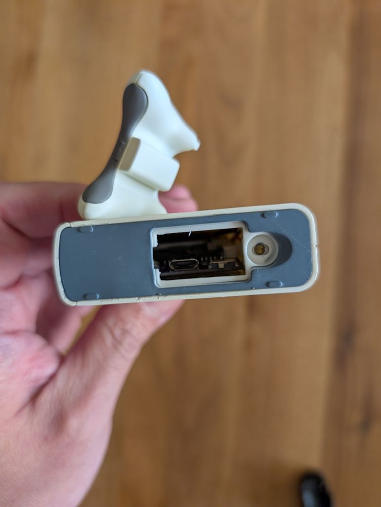 The bottom of the Hallmark XBOX 360 ornament with battery cover removed. Inside you can see a board with a small power switch and micro USB port