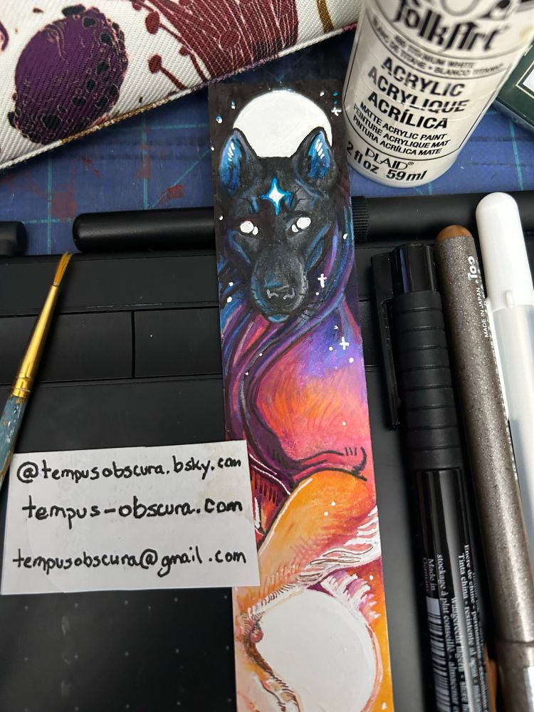 A small mixed media illustration of a sunset colored wolf in the sky.