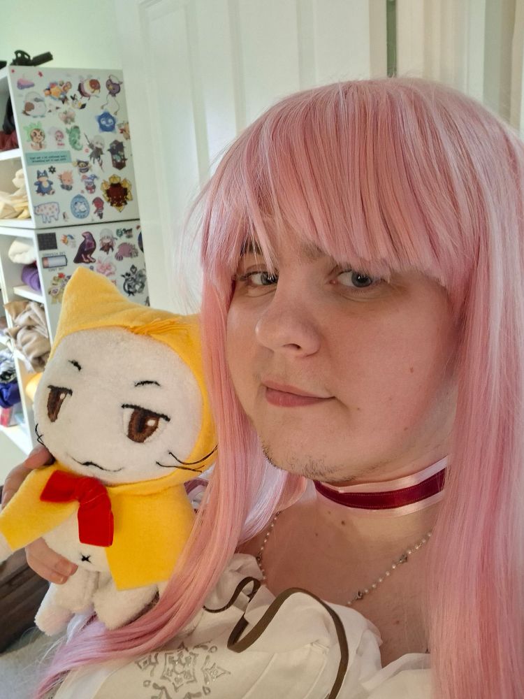 me! wearing a long pink wig and holding a momo plush