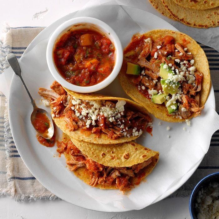 A plate of 3 tacos with salsa