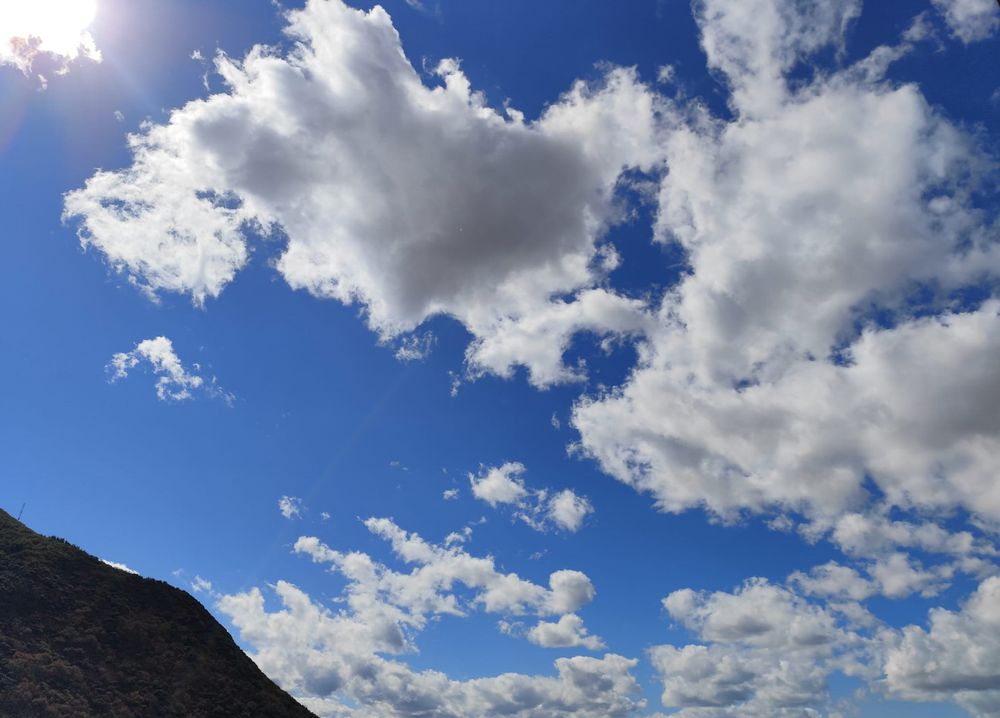 Cielo que parece de mentira pero es de verdad, muy azul, con nubes muy blancas y con una esquinina del Pajariel asomando a la izquierda. Dan ganas de irse a él.