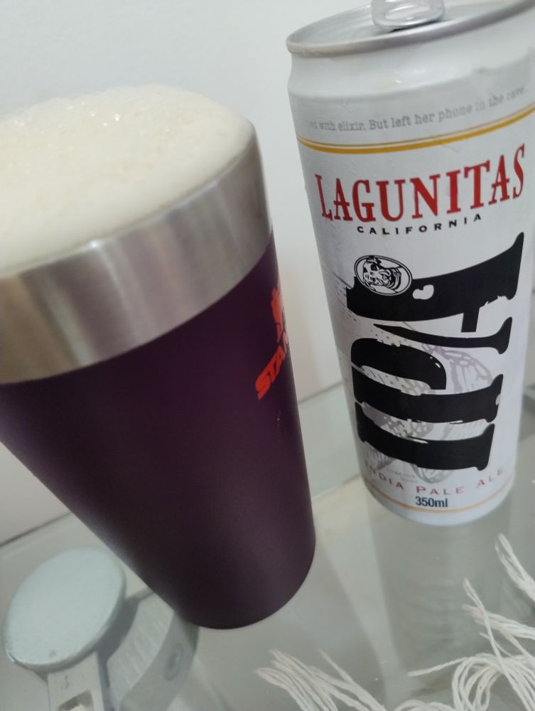 Copo Stanley com cerveja IPA Lagunitas, ao lado a lata da cerveja aberta.
