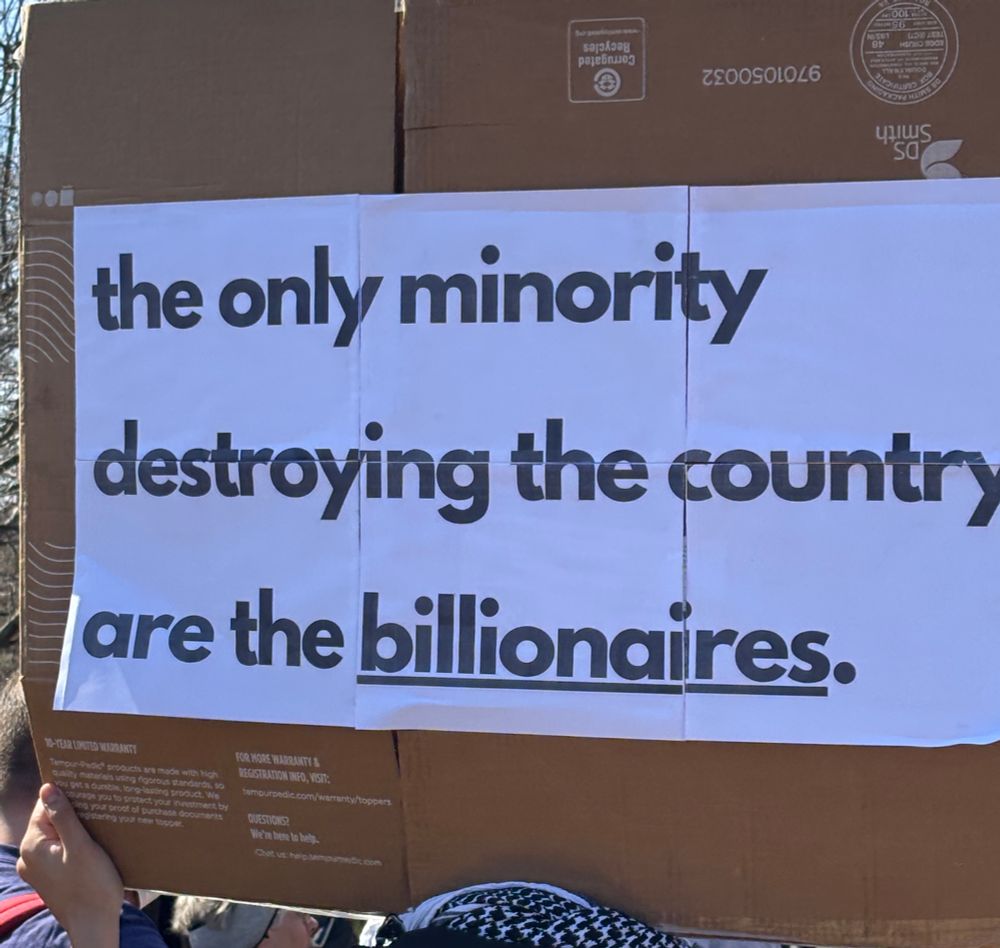 White sign black lettering reads the only minority destroying the country are the billionaires with billionaires underlined 