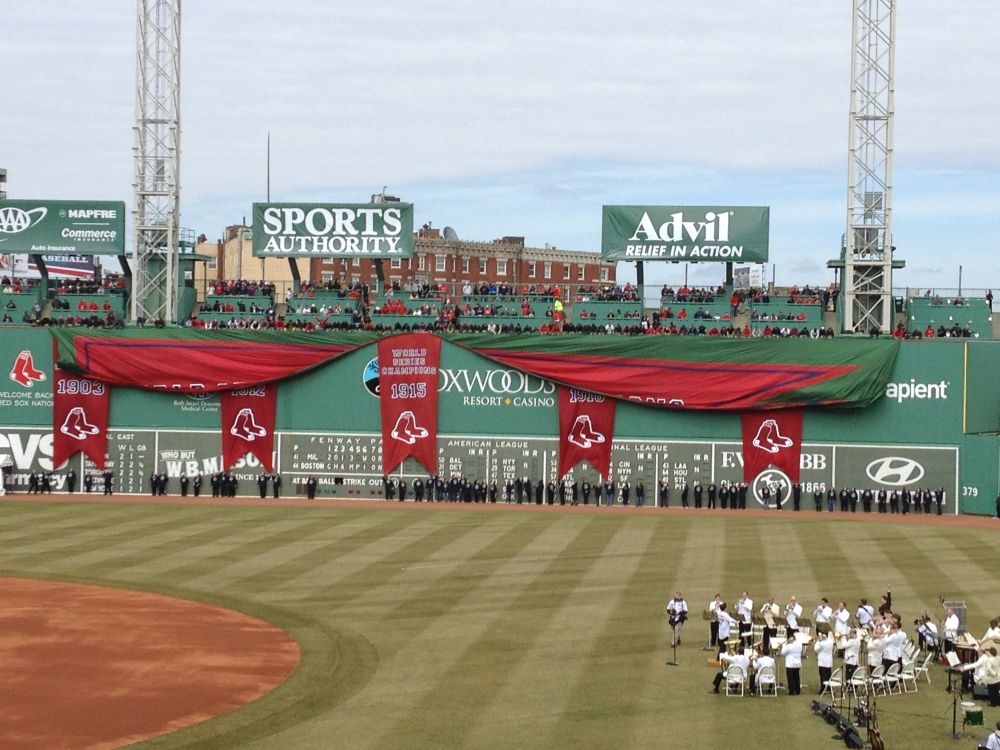 Picture of the Green Monster wall at Fenway on Opening Day, with red drapery representing championship wins 