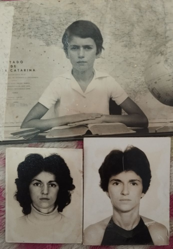 três fotos em preto e branco da minha mãe. 
em cima uma foto horizontal tradicional de escola, com mapa de santa Catarina ao fundo, globo terrestre no lado direto e minha mãe com 10 anos sentada com os braços apoiados sobre um livro grosso. ela é branca, olhos e cabelos escuros, veste uma camisa branca, os cabelos são curtos estilo "joãozinho". a expressão é séria.
abaixo, na esquerda, uma foto 3/4 em que ela está com 20 e poucos anos, cabelos volumosos um pouco acima dos ombros, blusa clara de gola alta e expressão séria. ela está linda!
à direita, outra foto 3/4. nesta ela está com 18 anos, cabelo curtinho, blusa preta e expressão séria. 
