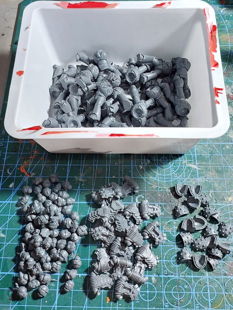 space marine parts assorted into piles of helmets, power packs, shoulders, and bodies