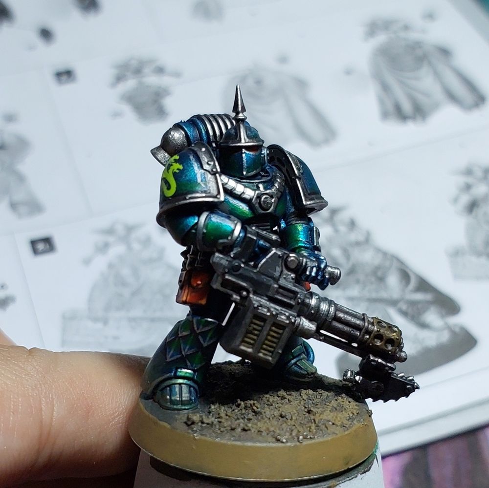 A painted Alpha Legion space marine carrying a chain cannon.