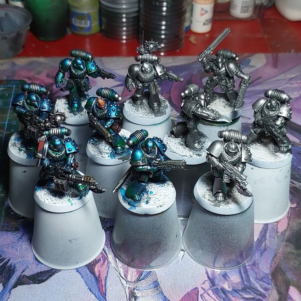 10 space marine models from the Alpha Legion in varying stages of completion