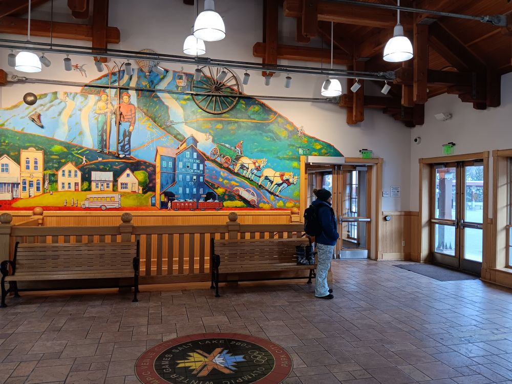 Indoor view of Old Town Transit Center, which looks like a nice rail station, with wall mural, wooden benches, and good lighting.