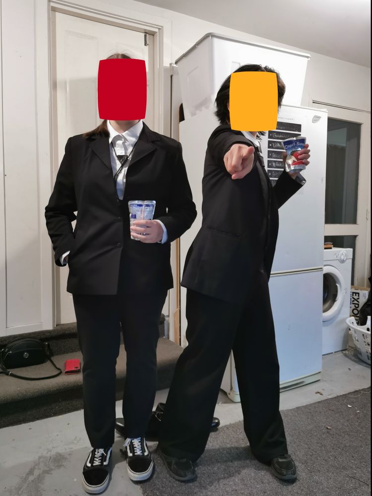 Two people standing next to eachother with capri suns
One is standing up straight and the other is pointing at the camera 