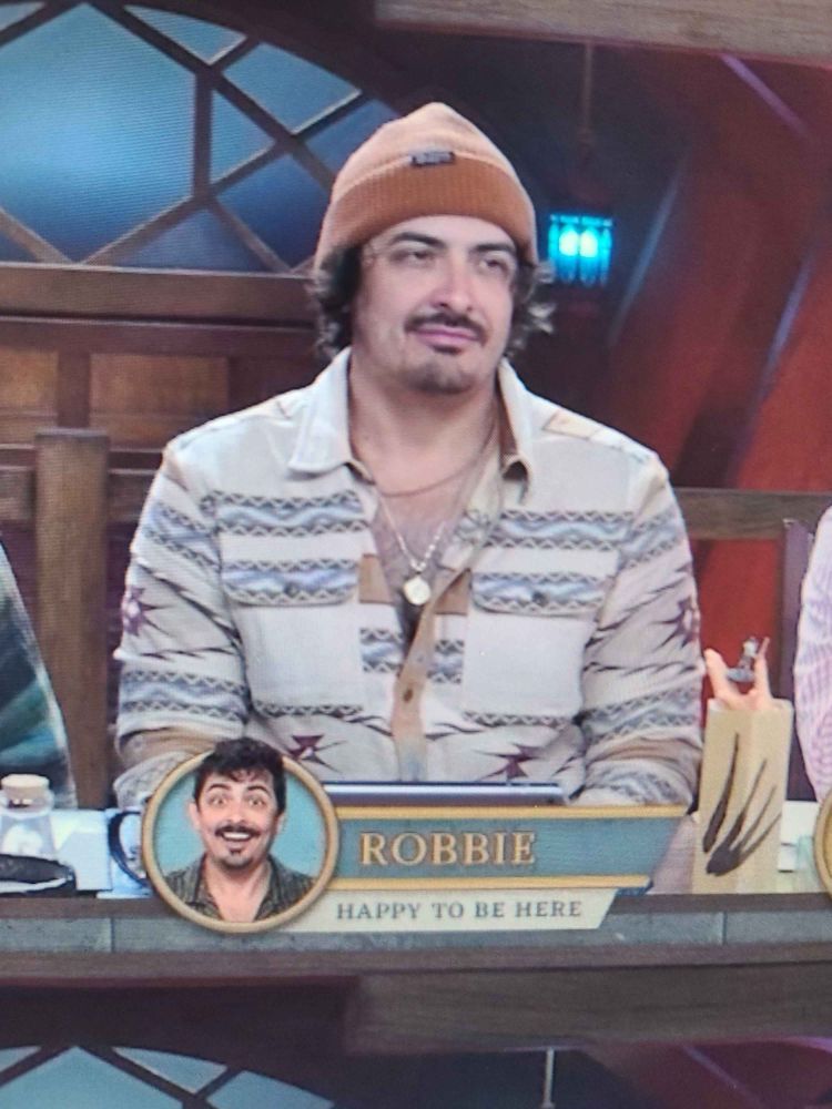 A picture of voice actor Robbie Daymond looking perturbed, captioned by a picture of him looking happy and text that says "Robbie, Happy to be here".