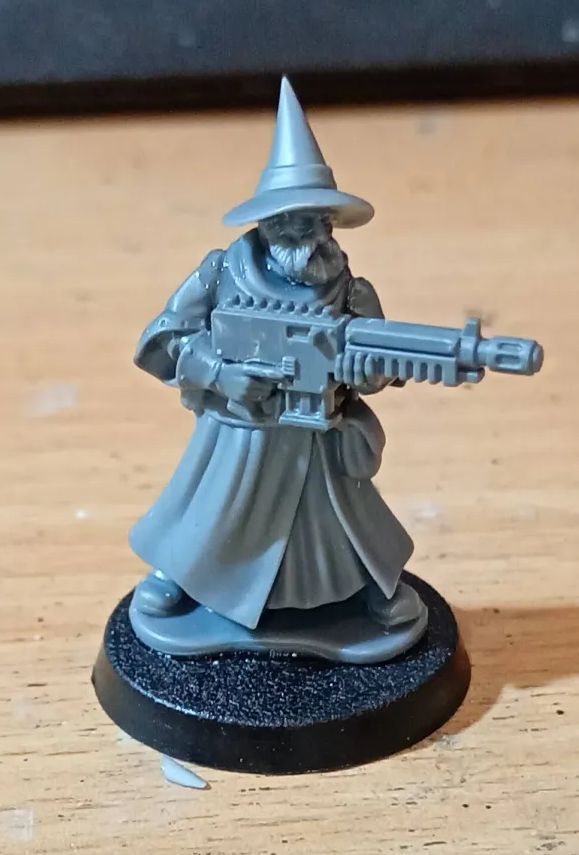 an unpainted miniature of a wizard with a rifle