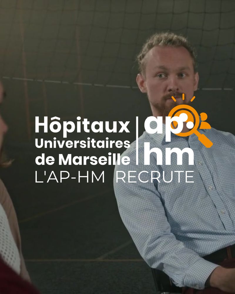 Homme barbu aux cheveux attachés, assis et regardant vers la gauche dans une salle. Texte : Hôpitaux Universitaires de Marseille – L’AP-HM recrute.