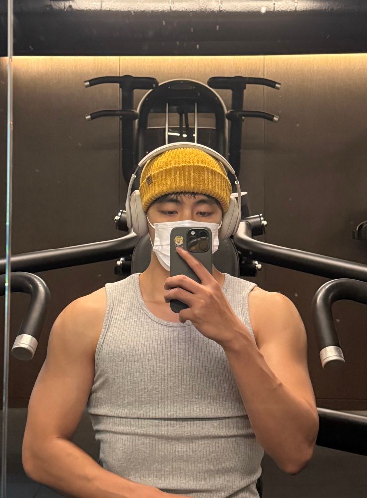 taehyung being a MENACE in a grey tank top showing off his beefy ass arms wearing a mask and a yellow beanie