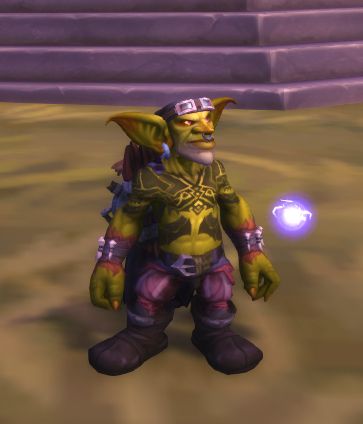 A male goblin with no shirt and lots of tattoos, he has large ears and a bandana on his head pinned in place by goggles.