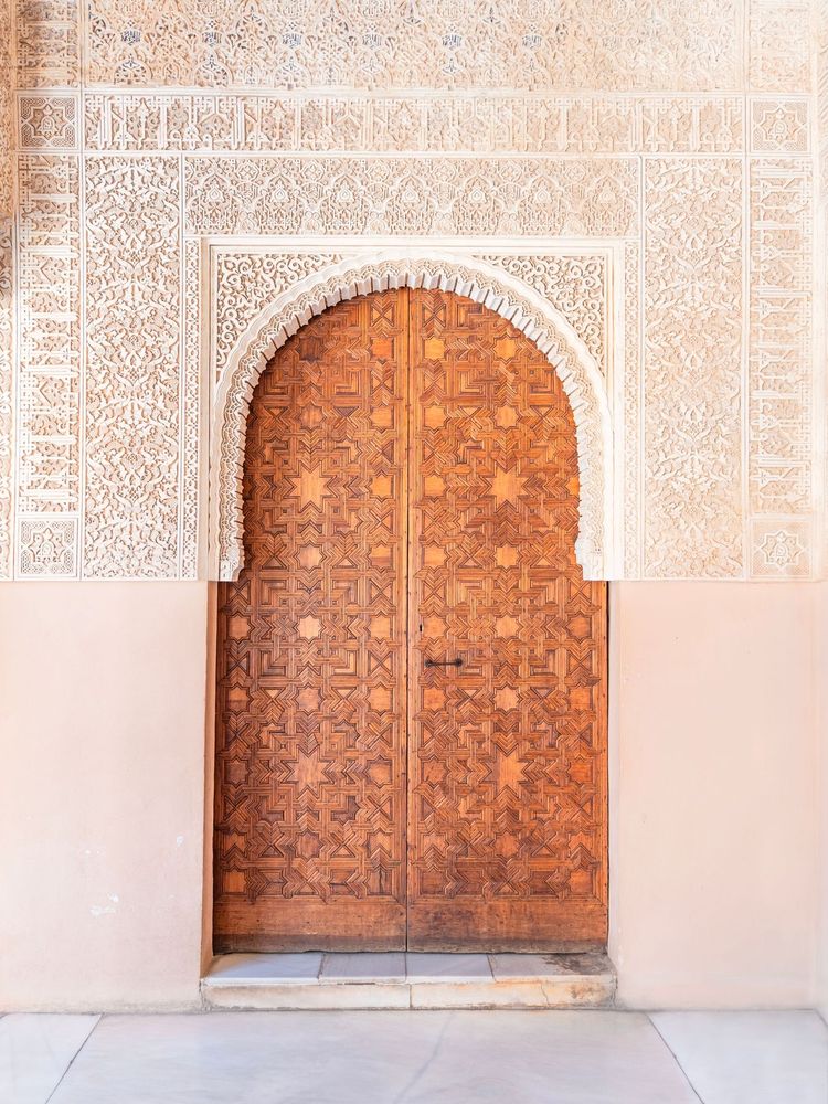 Immerse yourself in the breathtaking artistry of the Alhambra in Granada with this stunning art print. Capturing the intricate craftsmanship of Moorish architecture, this piece showcases a beautifully carved wooden door framed by an ornate stucco archway—an emblem of history, elegance, and cultural richness. The mesmerizing geometric patterns and delicate arabesque designs transport you to the heart of Andalusia’s most iconic palace. Perfect for art lovers, history enthusiasts, and interior designers seeking a statement piece that blends tradition with sophistication. Bring the grandeur of the Alhambra into your space and let its timeless beauty inspire you every day.