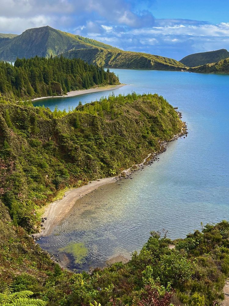 The twin lakes of Sete Cidades on São Miguel Island, viewed from a lush green ridge. This volcanic wonder in the Azores blends vivid blue and green waters with dramatic landscapes.