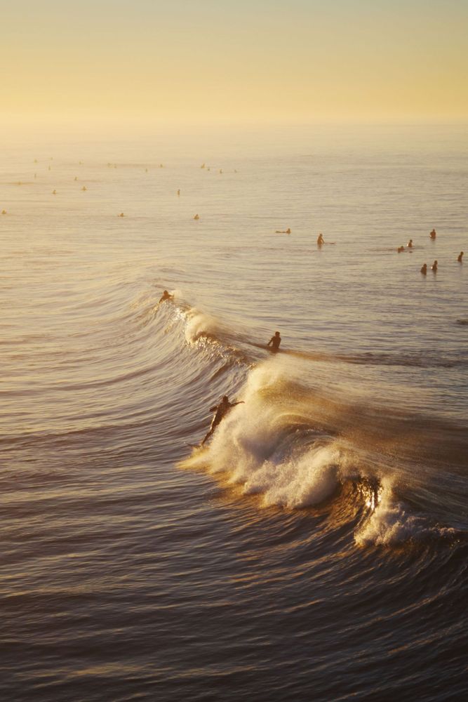 Surfer at sunrise from Huntington Beach Pier. Huntington Beach, Orange, County, California. 