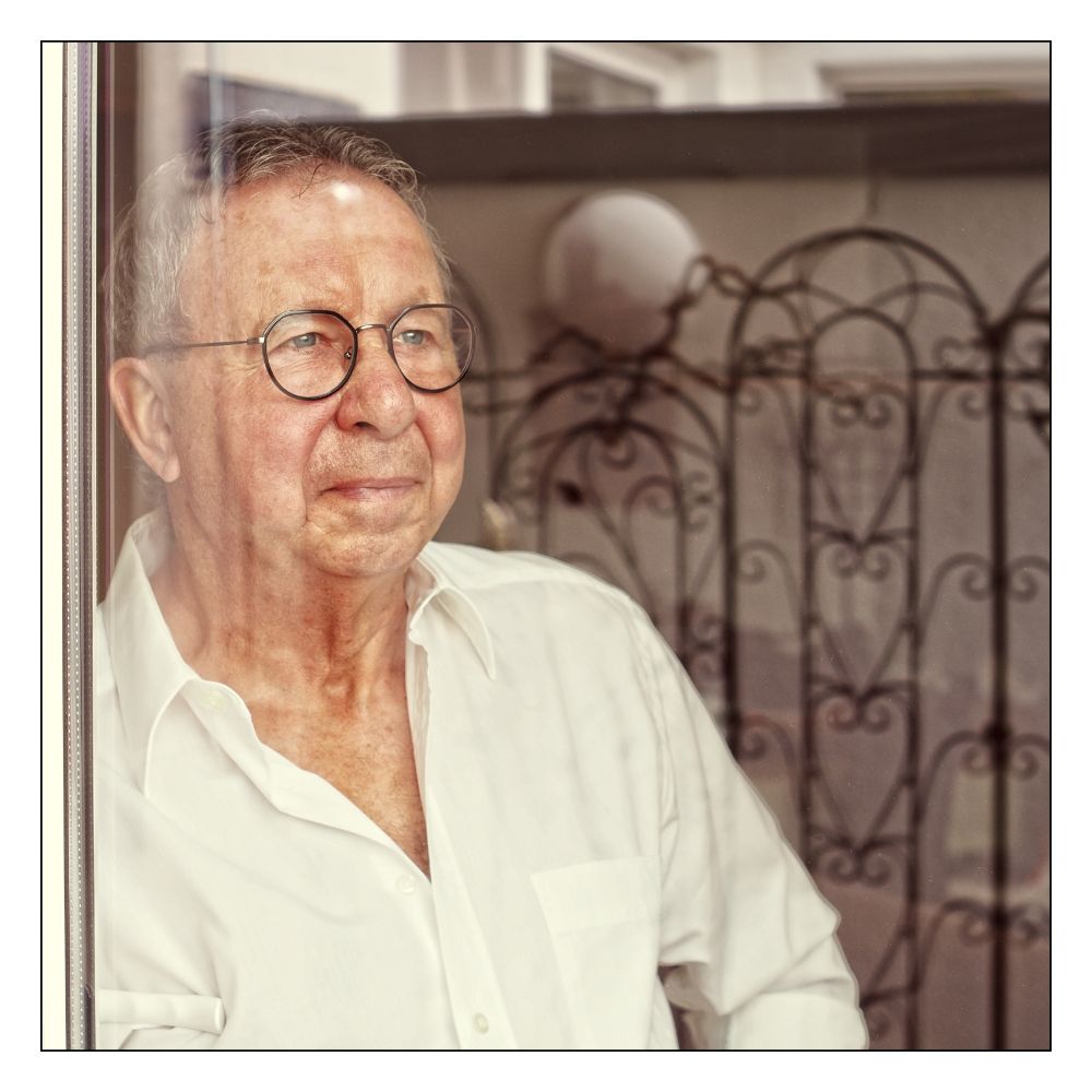 Älterer Herr hinterm Fenster.