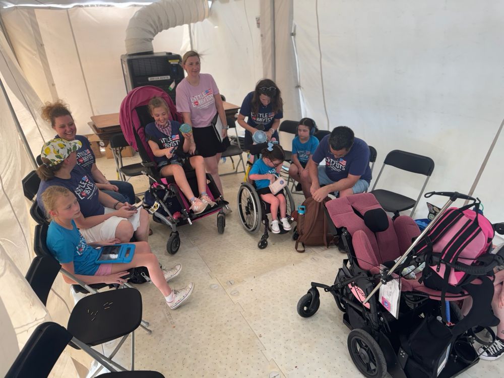 Little Lobbyists families sit in front of a livestream camera feed to read their Medicaid stories