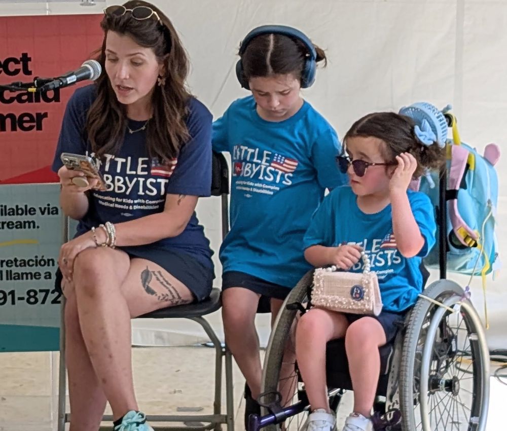Little Lobbyists families sit in front of a livestream camera feed to read their Medicaid stories
